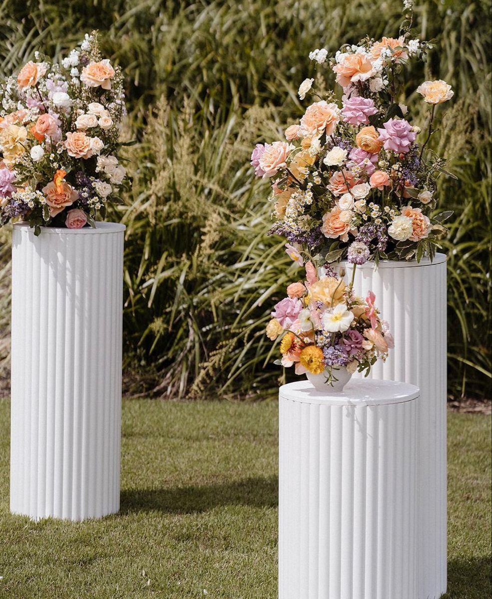 White ripple plinths styled with wildflower arrangements